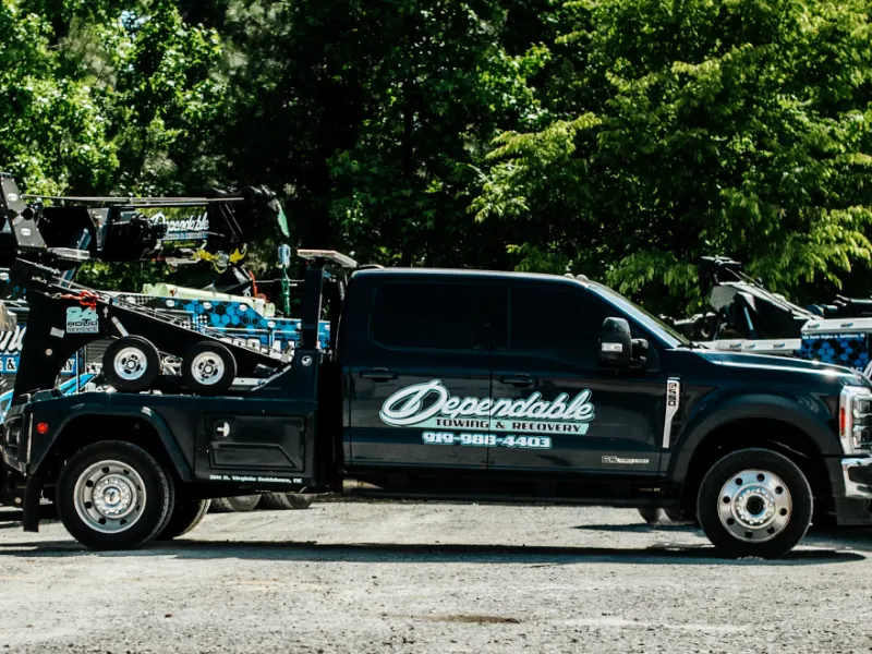Dependable pickup wrecker parked between two larger wreckers